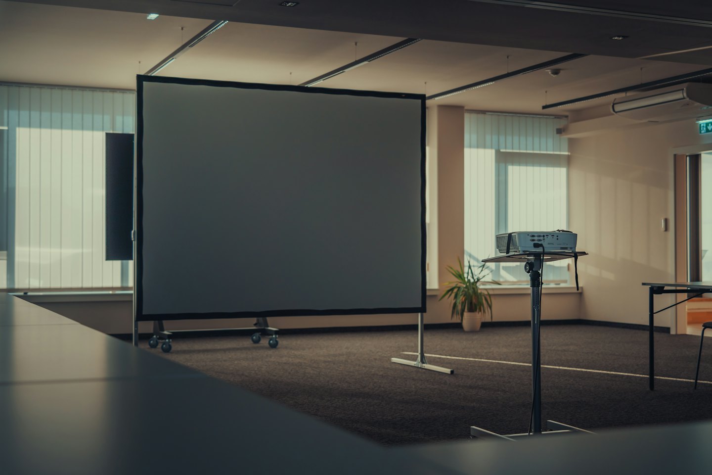 Empty conference room with projection screen and projector ready.